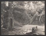 [Stone structure and wooden staircase in wooded area]
