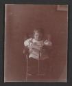 [Baby in high chair, leafing through book]