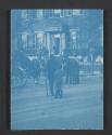 [Man with wreath speaking with a boy in the middle of a street]