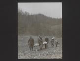 A Frontier Nurse carries a new baby while mountaineers carry the young, sick mother