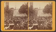 [Crowd gathered near monument]