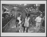 [Two women walking with a child]