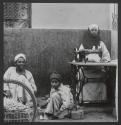 [Street scene with man at sewing machine, Egypt]