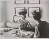 [Tuesday Weld trying to balance cushions and drink tea at the same time]