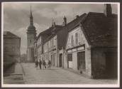 [Pedestrians walking on a city street towards a church]