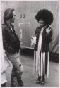 Man in conversation with actress in costume for bar scene with "Supremes-like" act in the TV series "Battlestar Galactica"