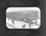 [Group of people walking next to train]