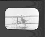 [Two people on a float biplane floating on water]
